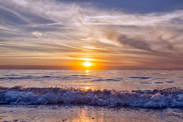 Fototapeta na wymiar Waves Approach the Shore at Sunset