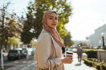 Muslim woman in the city with a cup of coffee - 299799004