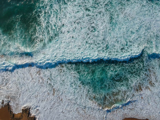 Sand beach aerial, top view of a beautiful sandy beach aerial shot with the blue waves rolling into the shore