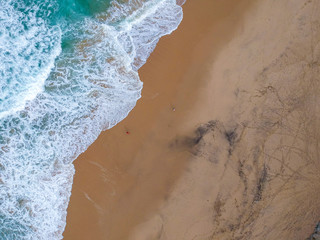 Sand beach aerial, top view of a beautiful sandy beach aerial shot with the blue waves rolling into the shore
