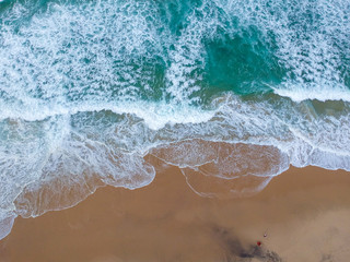 Fototapeta na wymiar Sand beach aerial, top view of a beautiful sandy beach aerial shot with the blue waves rolling into the shore