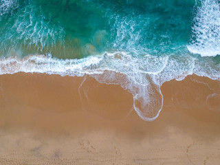 Sand beach aerial, top view of a beautiful sandy beach aerial shot with the blue waves rolling into the shore