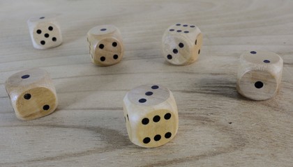 Six wooden dice with black points. Random placement. On the gaming table.