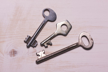 three iron key lies on a white wooden surface