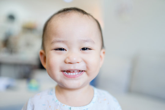 Happy Little asian baby boy child showing front teeth with big smile and laughing: Healthy happy funny smiling face young adorable lovely kid.Joyful portrait of asian elementary preschool.