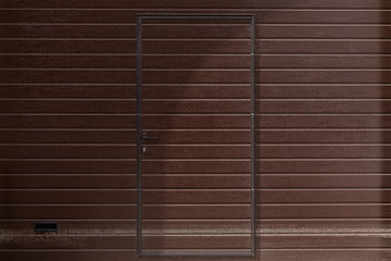 Doors in the color of the walls, walls patterned with wooden clapboard painted in brown, front view