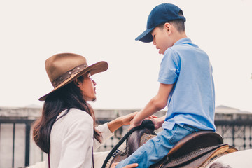 A child with special needs is riding with a close supervision teacher].This is a treatment called...