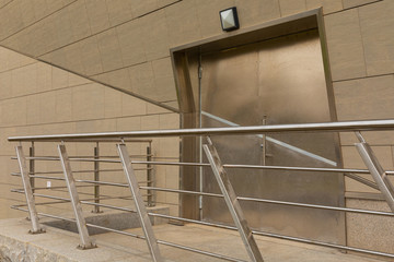 Futuristic design with gray cement walls, metal door and steel fence