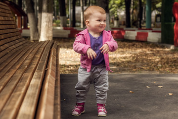 A small child sitting at a bench in the Park