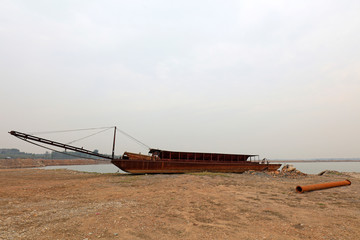 Simple sand dredger by river bank