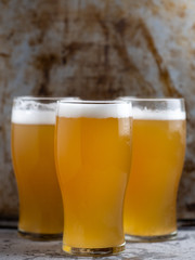 three glasses of light unfiltered beer close up
