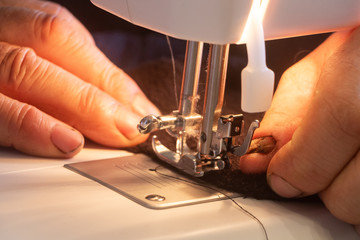 Man repairing a clothe with a sewing machine