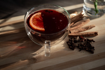 mulled wine on a wooden tray with orange and spices. Mulled wine ingredients. Winter cocktail. drink in a double bottom cup.