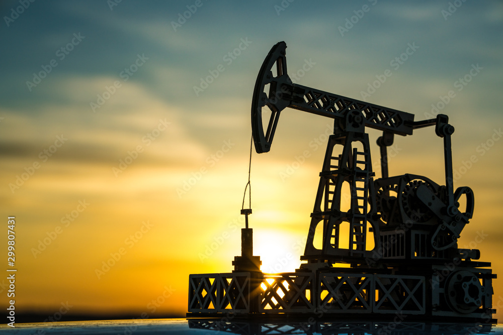 Wall mural oil pump on a sunset background. oil production, fuel, natural resources.