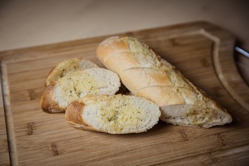 Tasty garlic bread, baguette on kitchen board