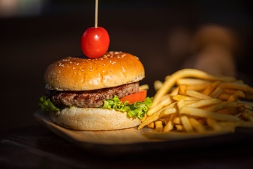 tasty hamburger and fried potatoes