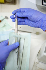 Nurse packs a dental instrument before its sterilization in a dental clinic - concept of modern technology in medicine