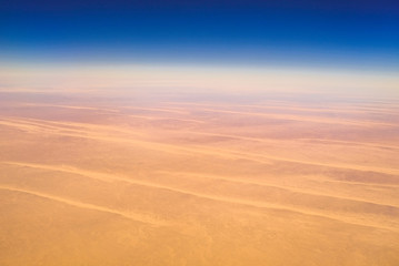 Obraz na płótnie Canvas Aerial airplane view of barren Sahara desert landscape in Egypt