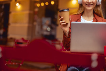 Smiling girl holding a paper cup in her hand