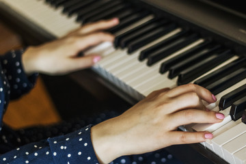 Hands of the girl pianist on the keys during the game