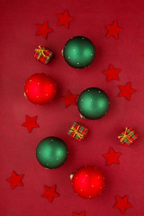 Christmas decoration with xmas ornaments, pine tree, gifts with copy space over the red background
