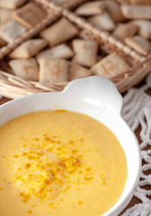 Pumpkin cream spiced with curry in a white bowl with roasted pumpkin. Close Up