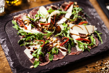 Beef carpaccio served on a board in restaurant