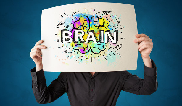 Young person holding white paper in front of her head with colorful brain concept