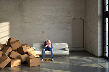 Verzweifelte Frau sitzt auf Sofa neben vielen Umzugskartons