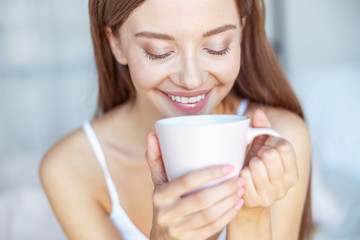 Portrait of charming brunette that looking into her cup