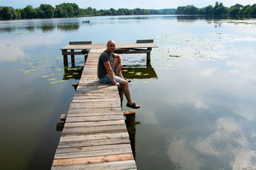 view of boy with casual clothing on wooden pier. summer day. Concept freedom