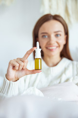 Cheerful young female person demonstrating her spray