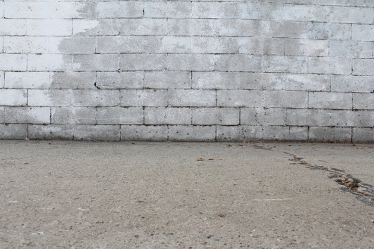 Old White Painted Brick Wall And Cement Sidewalk