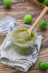 Fresh feijoa jam in a glass jar on the wooden background