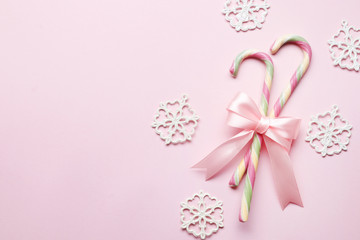 Creative minimal christmas art. The pattern is made with Christmas candies, bow, snowflake on a bright pink background. The apartment was lying. Space for copy. Minimum composition.