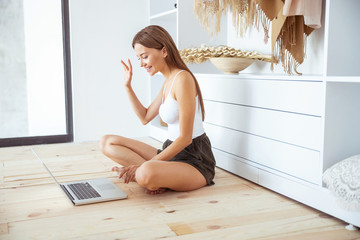 Positive delighted long haired girl waving her hand