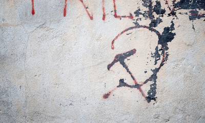 Communistic symbol: Grungy hammer and sickle graffiti on and old wall