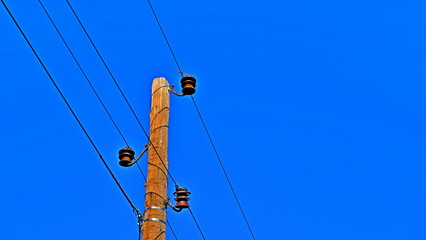 The pillar is electric. Electric wires. Power lines. Crows on wires