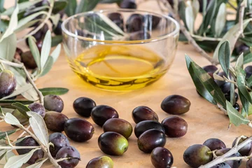 Foto op Plexiglas Olive oil in a glass bowl and freshly picked olives © LaSu