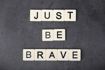 A motivational quote Just be brave formed with tile letters	