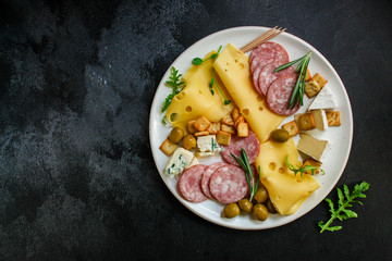 cheese board (different types of cheese plate appetizers , sausage, ham, olives, greens and more) menu concept. food background. copy space. Top view