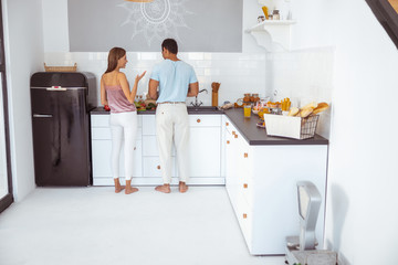 Man and woman cooking breakfast in their kitchen