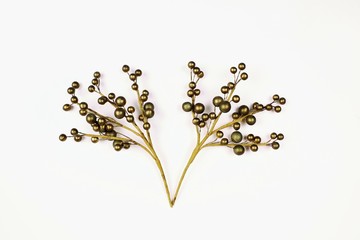 Christmas decoration in the form of a golden branch with balls on a white background.