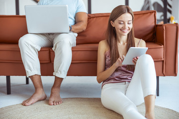 Cheerful long haired girl using her modern gadget