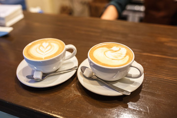 two cups of coffee on a table in a cafe