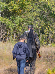 Hunters with weapons and children go hunting