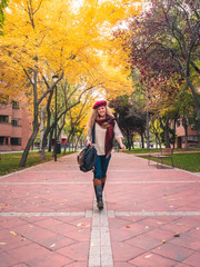 Fototapeta premium young travel woman in autumn outfit smiling looking at pretty autumn colours