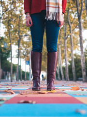 middle plane of women's boots on a nice floor of colored squares with autumn leaves and a lot of blurring of the background