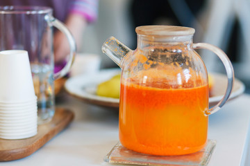 Jug with pumpkin tea on the table.