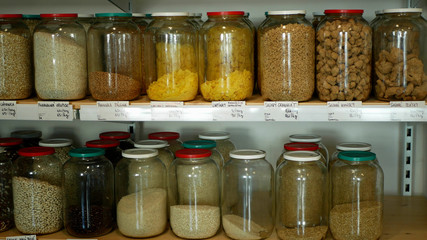 Shop without packaging, healthy nutrition wide assortment of cereals, legumes, dried fruits, nuts, flour in jars and glass bottles on their own bags, without packaging store, raw materials